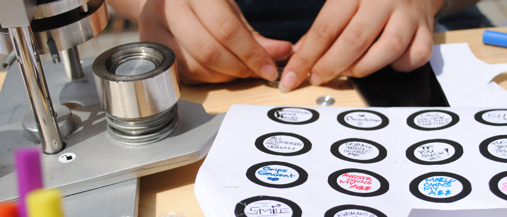 Jugendliche*r erstellt Buttons in einem Workshop