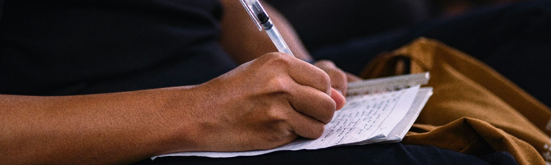 Person macht Notizen bei einer Konferenz