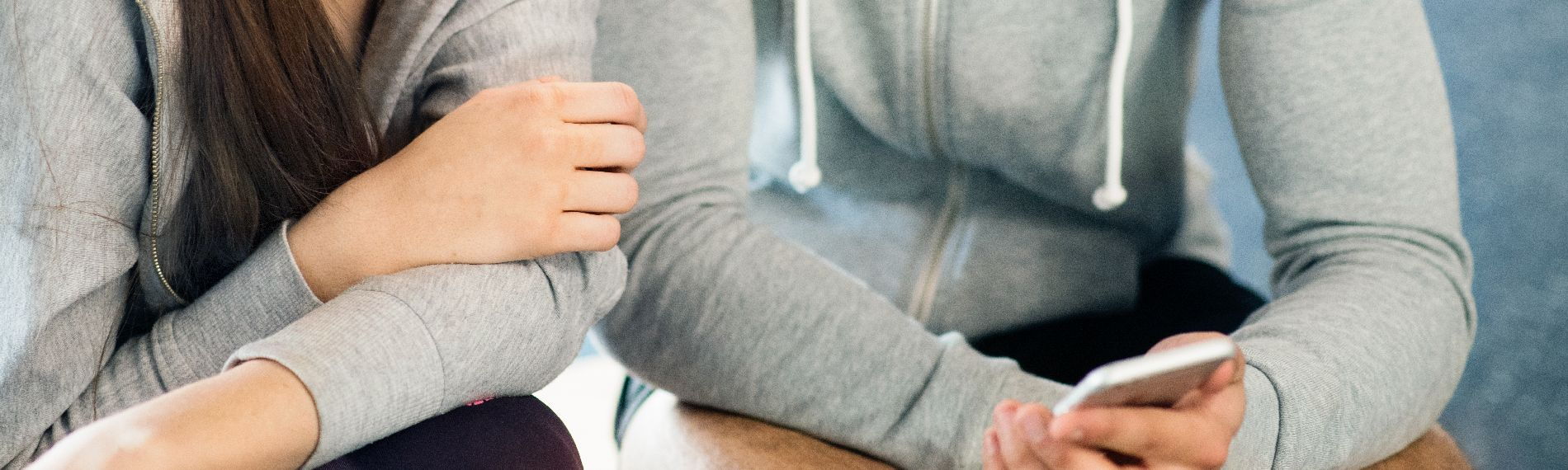 Two teenagers looking at a smartphone
